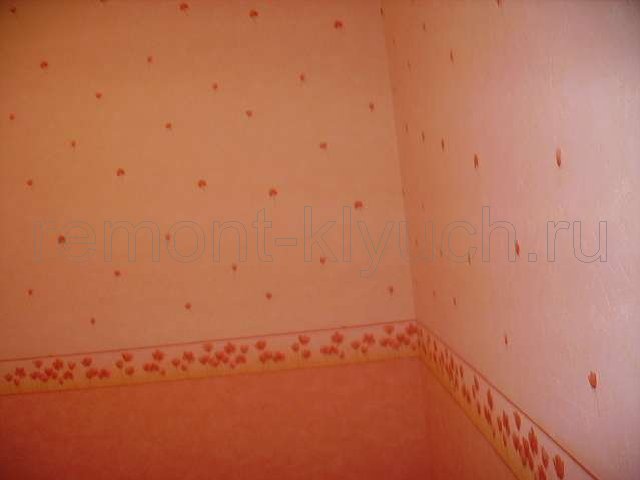 Вид угла стен комнаты, оклеянными виниловыми обоями двух тонов без подбора рисунка, установка бумажного бордюра