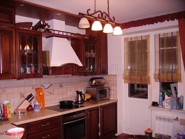 Вид кухни после ремонта с мебелью, техникой и шторами