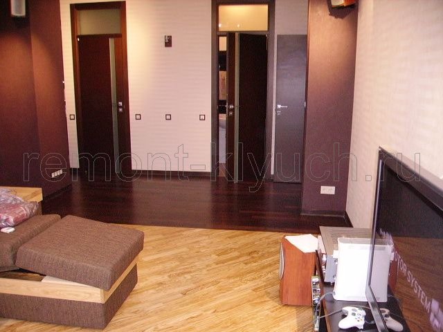Вид напольного покрытия пола комнаты и коридора из паркетных досок, установка напольного плинтуса, завоз мебели