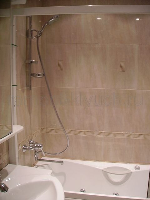Облицовка стен ванной комнаты керамической плиткой с декором и бордюром, установка ванны, умывальника, смесителей, штанги под лейку смесителя, полочки с зеркалом