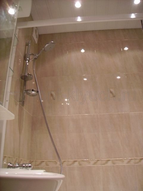 Облицовка стен ванной комнаты керамической плиткой с декором и бордюром, устройство подвесного реечнго потолка с точечными светильникми