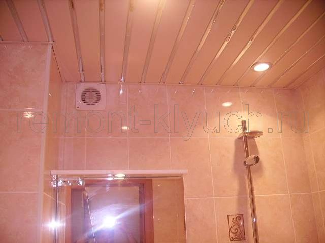 Устройство подвесного реечного потолка с встроенными точечными светильниками, облицовка стен санузла из керамических плиток стандартного размера с затиркой швов, установка вентилятора, стойки для лейки душа, зеркала с полочкой 