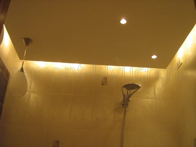 Вид подвесного потолка с точечными и навесными светильниками, внутренней подсветкой в ванной комнате