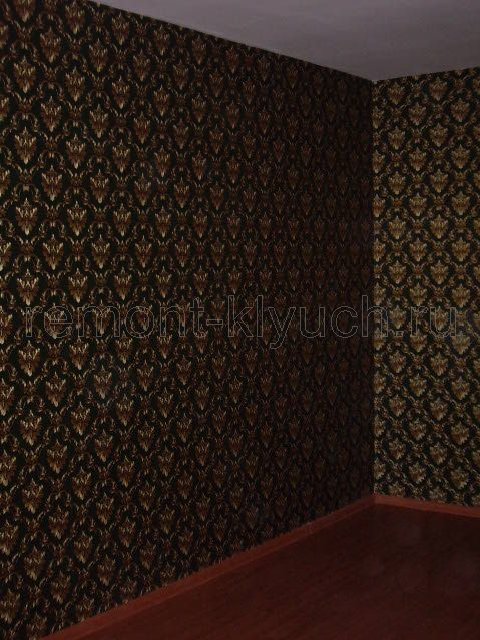 Общий вид стен комнаты с оклеянными виниловыми обоями с рисунком, устройством пола из ламината, установленным напольным плинтусом