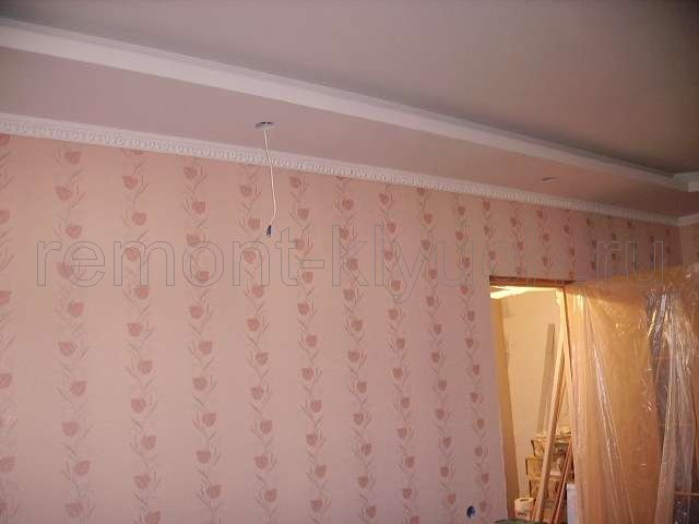 Оклеянные стены комнаты виниловыми обоями с рисунком, высверливание отверстий в подвесном потолке из гипсокартона, протягивание проводов для установки точечных светильников