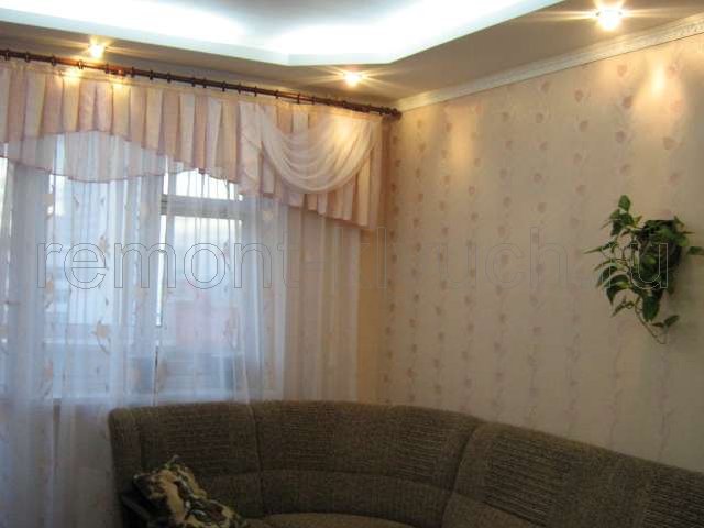 Вид гостинной комнаты после ремонта с мягкой мебелью и шторами