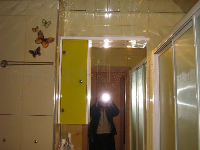 Облицовка стен санузла керамической плиткой с декором и затиркой швов, установка зеркала с полочками, установка пластиковых раздвижных шторок для ванны