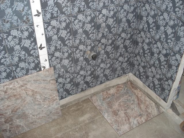 Облицовка стен санузла керамическими плитками с декором, устройство цементной стяжки пола, начало укладки керамических плиток на полу санузла