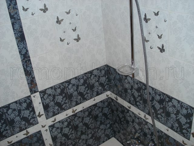 Готовый вид облицовки стен ванной комнаты керамическими плитками двух тонов и устройствами бордюра, декора
