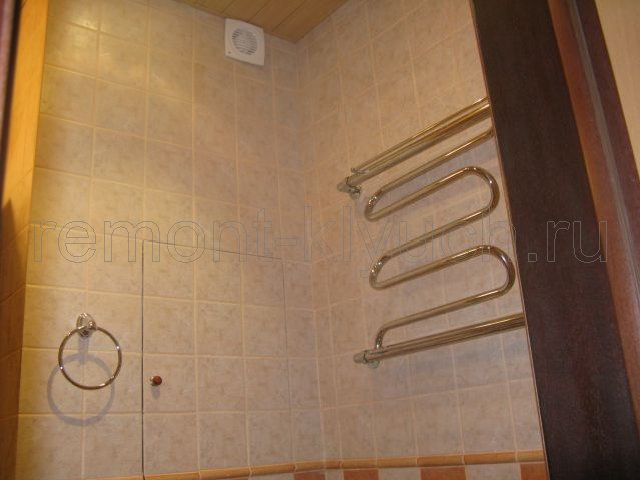 Облицовка стен санузла и дверцы лючка короба керамическими плитками с затиркой швов, установка полотенцесушителя, вентилятора и сантехнических аксессуаров