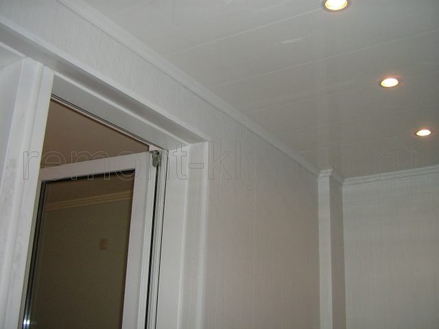 Вид устройства подвесного потолка из пластиковых панелей ПВХ с встроенными светильниками на лоджии, установка потолочного плинтуса
