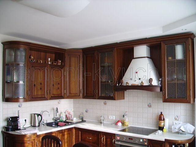 Установленная кухонная мебель с бытовой техникой и вытяжкой, устройство фартука из керамических плиток с декором