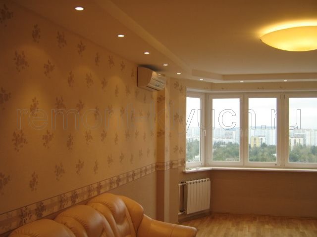Вид гостинной комнаты с мягкой мебелью и оклеянными стенами виниловыми обоями с рисунком 