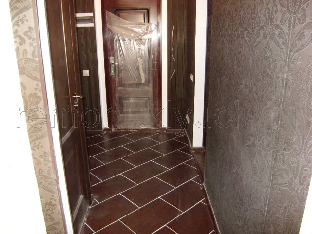 Вид устройство половв коридоре из керамических плиток с затиркой швов, выложенных по диагонали, установка напольного плинтуса, монтаж межкомнатных дверей