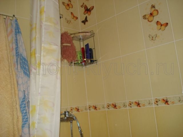 Окончательный вариант облицовки стен ванной керамическими плитками с декором, навеска штор из пэ для душа