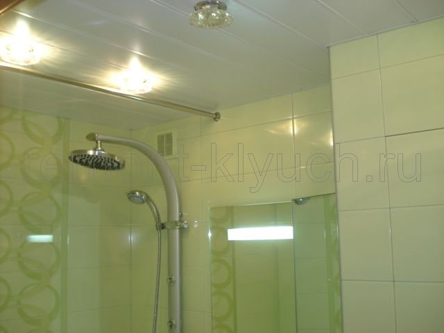 Установка реечного потолка с встроенными точечными светильниками, облицовка стен керамической плиткой с декором, установка штанги для шторки ванной