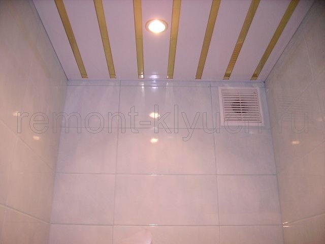 Готовый вид облицовки стен туалетной комнаты керамическими плитками, устройства реечного потолка, установка вентилятора