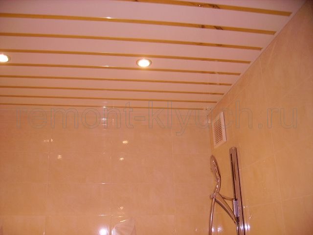 Готовый вид облицовки стен ванной комнаты керамическими плитками, устройства реечного потолка с точечными светильниками, установка вентилятора и стойки для лейки душа